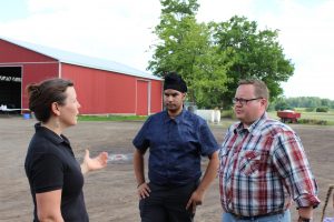 Jenn Pfenning engaged in conversation with 2 HUMA representatives on the farm