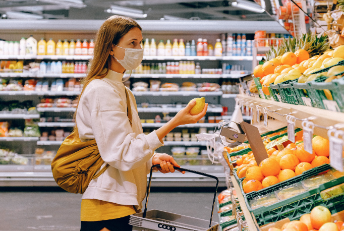 Woman grocery shopping with mask.