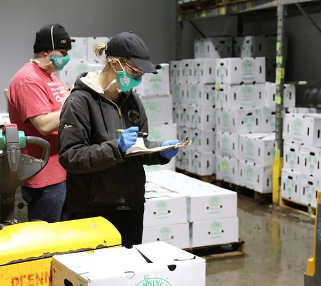 Staff working in warehouse wearing face masks and gloves.