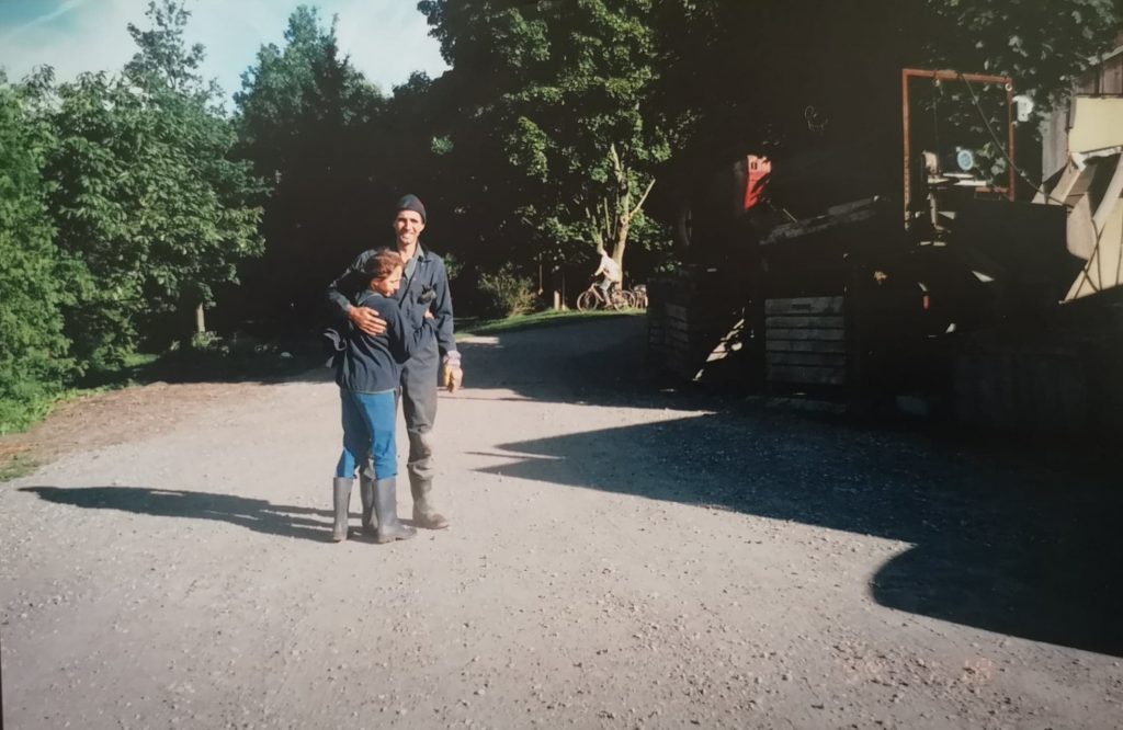 Young Erika and Wolfgang hugging in their rubber boots on the farm.